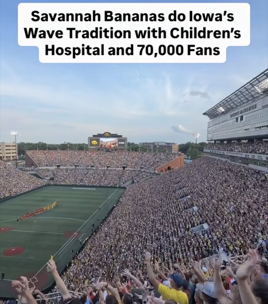 The Savannah Bananas and fans perform the Hawkeye Wave in Iowa City.