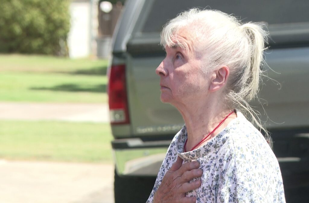 Hazel Hayes watches the Costless Plumbing, Heating and Air Conditioning company replace her AC unit for free in Fresno, Calif.